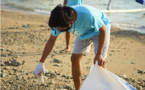 person collecting plastic at beach